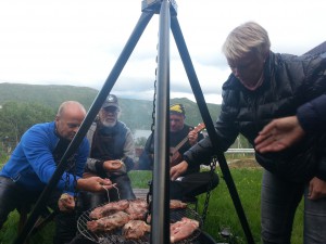 Grilling på bålpanne, en hyggelig start på turen. Anne og Per Martin ordner grillmaten mens Tore spiller opp. Tor venter forventningsfullt. 