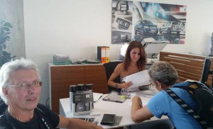 Hos BMW forhandleren i Cagliari, tar det bare 1,5 timer å fylle ut papirene. Den sardiske dama som skal ha alle opplysningene er imidlertid såpass søt, at gutta sitter lydige, selv om svært lite skjer.