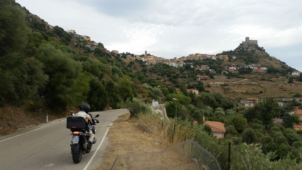 Vi nærmer oss en av Sardinias typiske landsbyer. Landskapet og utsikten skifter fort på Sardinia. Nesten som det skulle vært en konkurranse der så mange landskapstyper som mulig sloss om å få plass på minst mulig overflate. På dette partiet i nord er terrenget avslepent og rundt. 